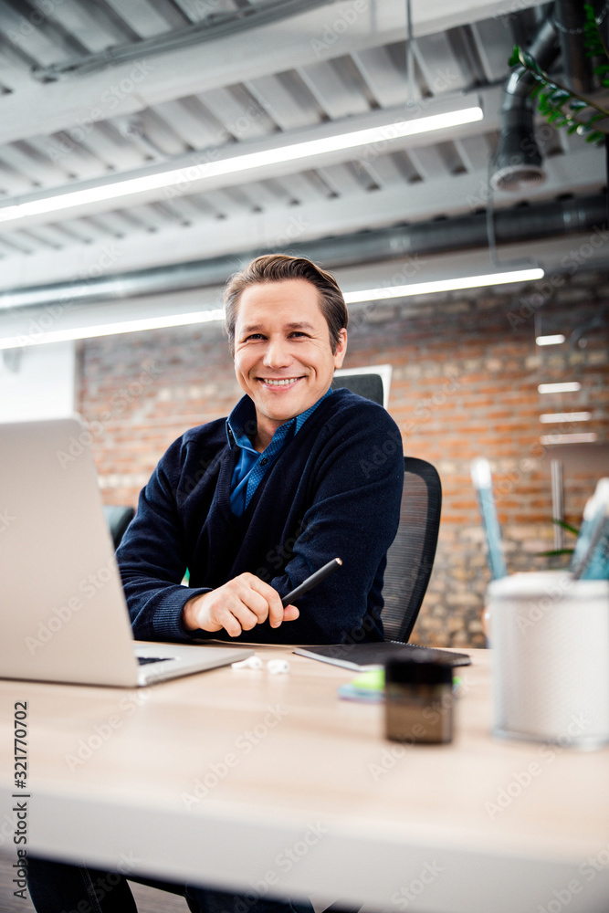 Positive delighted businessman looking straight at camera