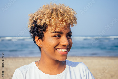 latin hispanic woman with perfect skin and curly afro hair enjoying at the beach