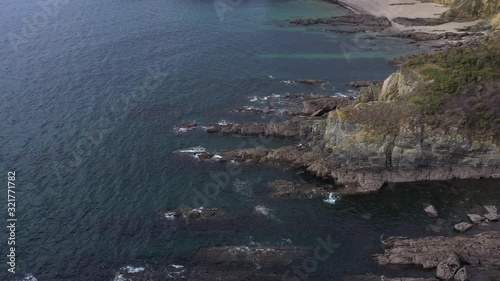 Aerial, tilt up, drone shot, panning around the rocky coast, revealing the Praia de Centeas and the Playa de Estacas beaches, on a sunny day, in Ares, A Coruna, Galcia, Spain photo