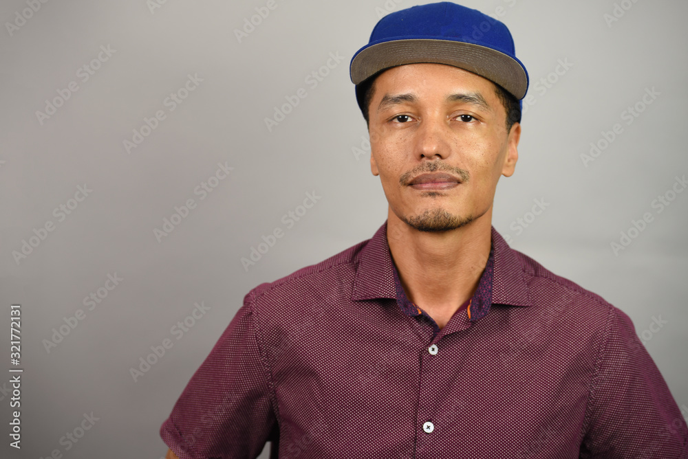 Portrait of a mixed race man wearing a blue baseball cap Portrait of a mixed race man wearing a blue baseball cap