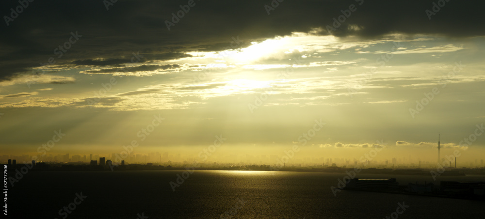 Obraz premium Tokyo skyline with sunlight peeking through the clouds