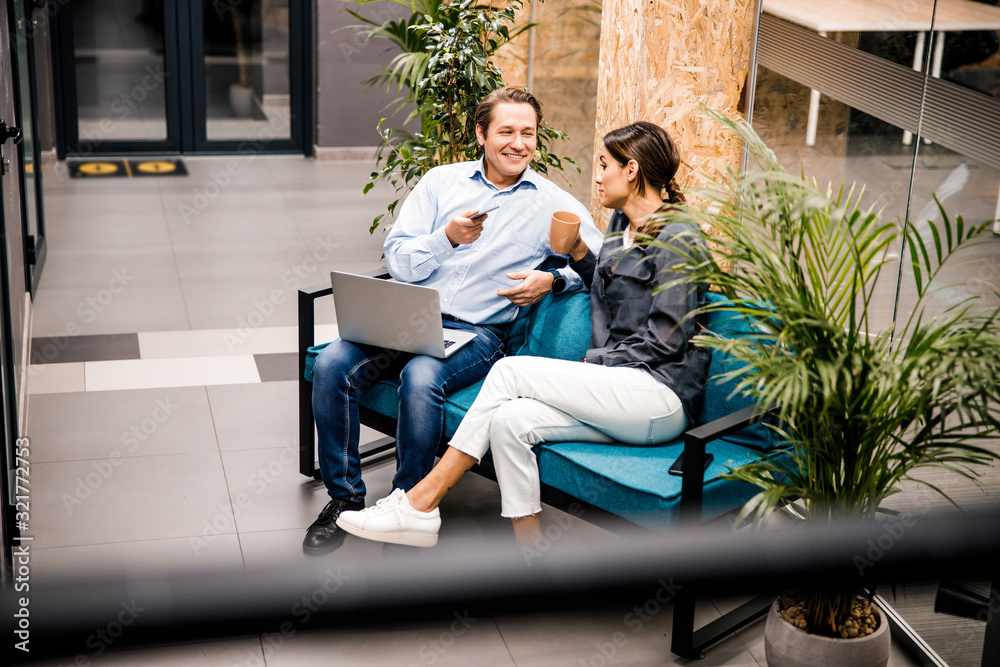 Obraz premium Handsome middle aged man talking to his colleague