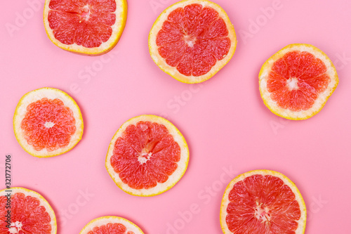Slices of grapefruit on a pink background