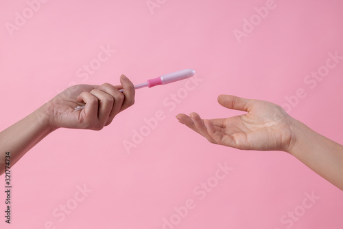 Obraz na plátně Girl giving tampon in applicator to her friend stock photo