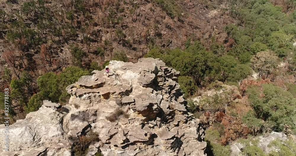 On the top of steep sandstone cliff in Blue mountains – a young girl enjoys her success. On the top of steep sandstone cliff in Blue mountains – a young girl enjoys her success.