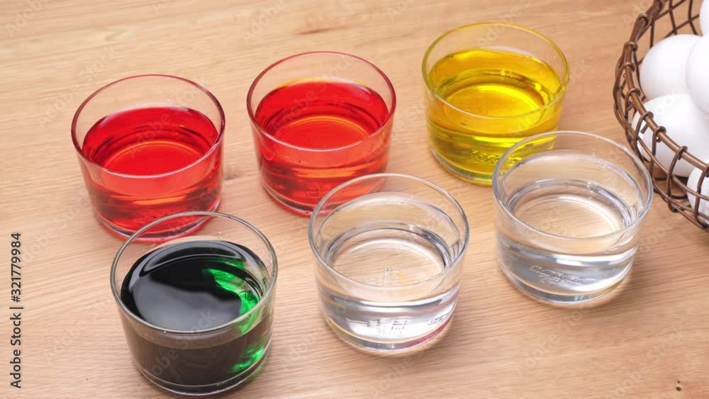 Young woman is dyeing easter eggs color at home kitchen table, design concept of preparing before egg hunting. 4K, close up shot. Young woman is dyeing easter eggs color at home kitchen table, design concept of preparing before egg hunting. 4K, close up shot.