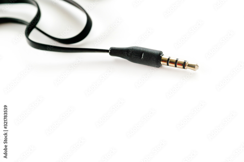 3.5 mm plug with a black wire, shot large on a white background. Background for music and computer equipment. 3.5 mm plug with a black wire, shot large on a white background. Background for music and computer equipment.