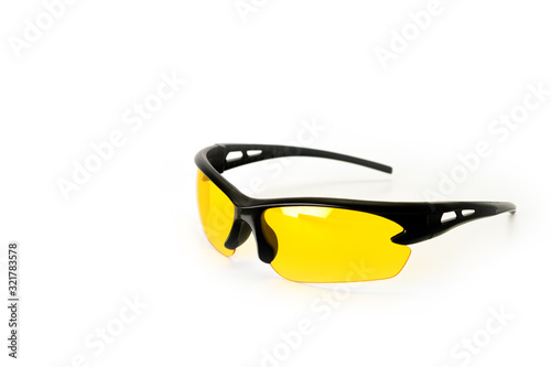 Sports and safety glasses made of black plastic with yellow glasses, shot on a white background. Background for cycling. Background for work safety.