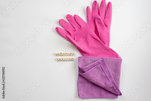 Pink latex gloves and .rag  lying on a white background. Concept cleaning service