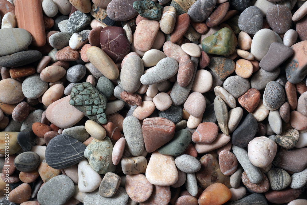 Gravel pattern of colored stones with shell. Abstract nature pebbles background.Small sea stones on the beach, vacation at sea. Top view Gravel pattern of colored stones with shell. Abstract nature pebbles background.Small sea stones on the beach, vacation at sea. Top view
