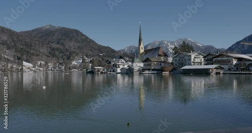 Rottach-Egern in Upper Bavaria. View from the shore of the lake Tegernsee in winter . The bootverleih, Church of St. Laurentius and mountain of Wallberg . Germany photo