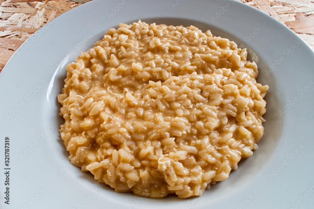 Rice with eggs and parmigiano reggiano on wooden table. Italian risotto with eggs and cheese Rice with eggs and parmigiano reggiano on wooden table. Italian risotto with eggs and cheese