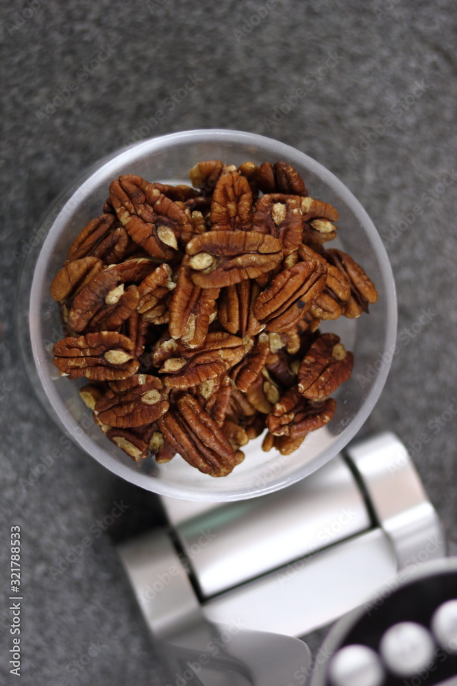 Weighing Pecan Nuts on Kitchen Scale. Making Chocolate, Pear and Pecan Pie Series. Weighing Pecan Nuts on Kitchen Scale. Making Chocolate, Pear and Pecan Pie Series.
