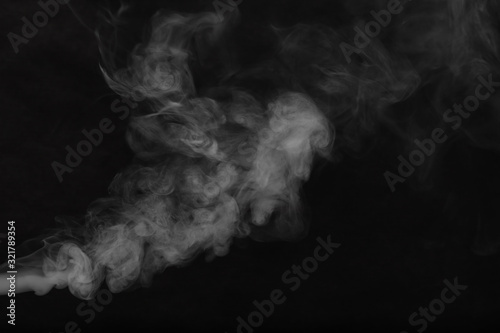 Obraz na płótnie White smoke on a black background. Texture of smoke. Clubs of white smoke on a dark background for an overlay