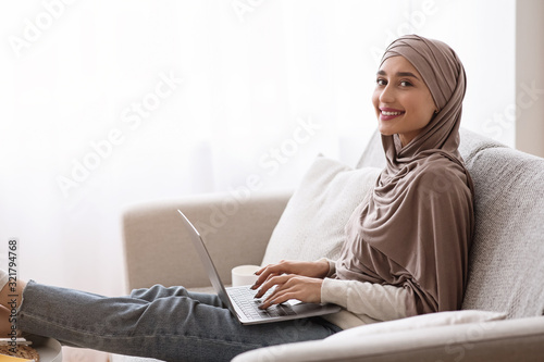 Smiling Girl In Hijab Using Laptop At Home, Studying Online