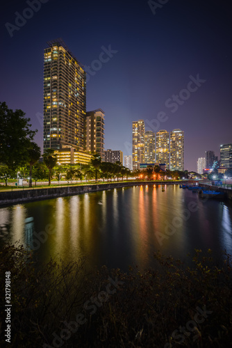 Along Kallang river  Singapore - 2019 - reflection of a building standing near the river bank during blue hour