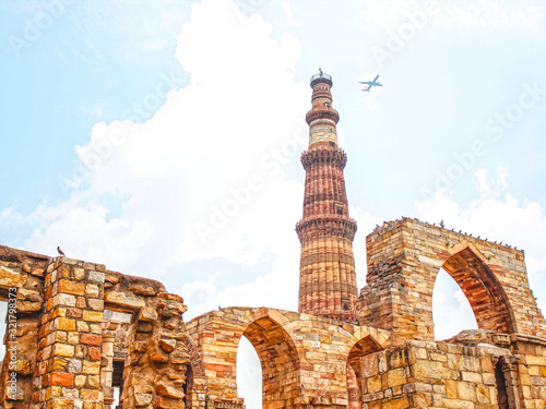 Delhi, India »; August 2016: A plane passing over Qutab Minar in the city of Delhi photo