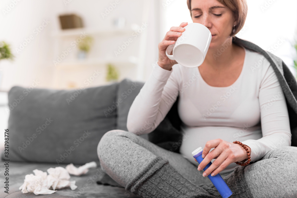Pregnant woman taking vitamin tablet in a glass of water. Pregnant woman taking vitamin tablet in a glass of water.