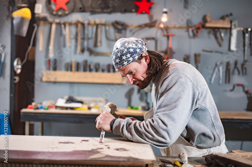 Carpenter working on a old wood in a retro vintage workshop.