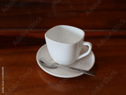 a white cup of coffee on a wooden floor