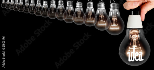Dark and Shining Idea Light Bulbs with Hand