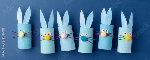 Happy easter kindergarten decoration concept - rabbit from toilet paper roll tube on classic blue background. Simple diy creative idea, banner. Eco-friendly reuse recycle decor, banner