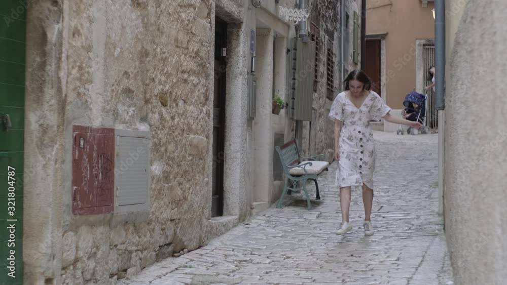 Joyful girl jumping and dancing in the town street. Rovinj, Croatia Joyful girl jumping and dancing in the town street. Rovinj, Croatia