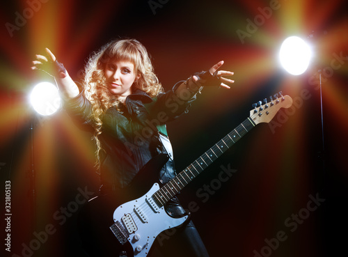 Girl guitarist with spotlights behind her