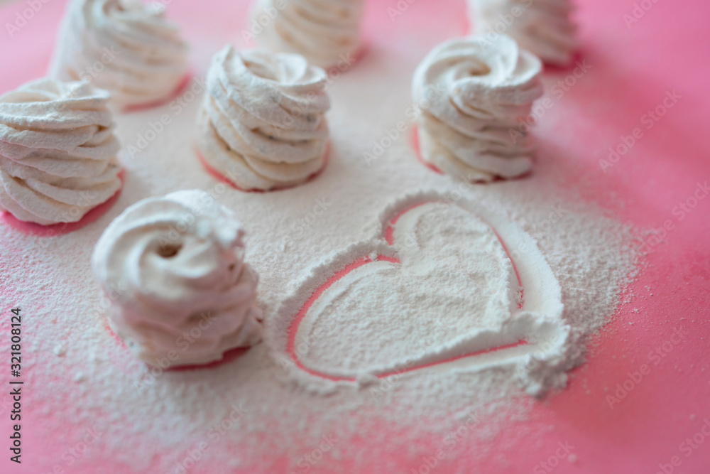 A lot of marshmallows on a pink background and heart drawing A lot of marshmallows on a pink background and heart drawing