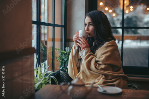 Young woman drinking tea sitting in cafe photo