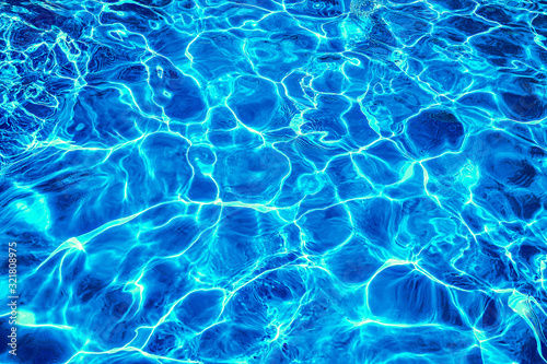 Abstract dark blue clear water in swimming pool. Neon light water effect. © nskyr2