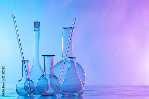 Chemical glassware is on the table. Flasks and test tubes on a lilac background. Chemical laboratory equipment. Dishes for demonstration of chemical reactions