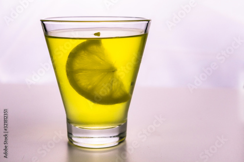  A slice of lemon in a glass with lemonade on a white background.