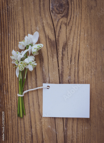 White flowers with blank label on wood