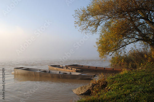 Drava river in Croatia, old traditional river boat by the lake shore in early autumn photographed in peaceful morning