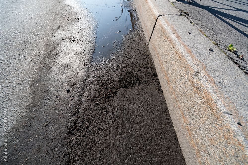 Puddles on the asphalt road with curb Puddles on the asphalt road with curb