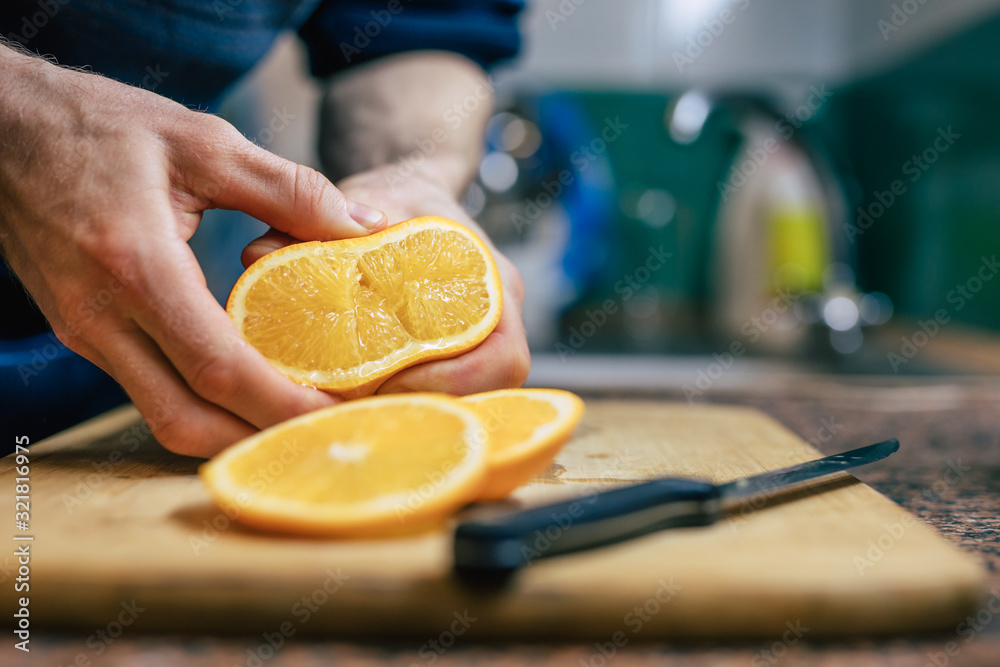 Close Up Of Man's Hands Pressing Juicy Orange Fruit