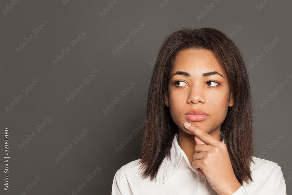 African American woman thinking on gray background African American woman thinking on gray background