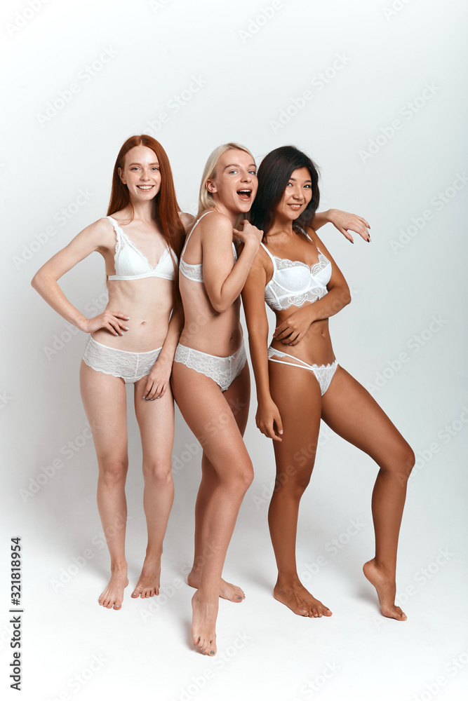 happy awesome Asian, Caucasian girls having fun in the studio with white wall, full length photo. isolated background.shopping, lifestyle,
