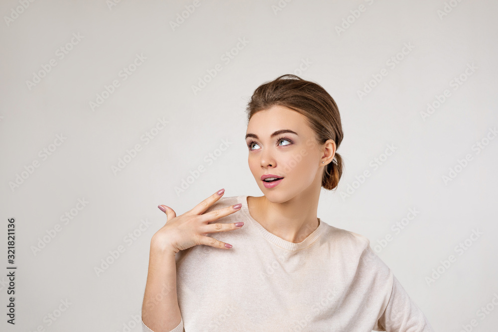 Obraz premium Portrait of young surprised beautiful woman screaming with shocked facial expression and looking to the side on gray background