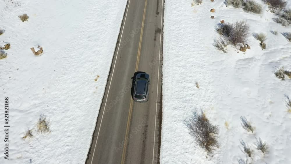 Aerial tracking suv car winter mountain road. Winter storm in rural farming community. Mountain valley seasonal cold weather. Snow and ice on road and landscape. Driving car Aerial tracking suv car winter mountain road. Winter storm in rural farming community. Mountain valley seasonal cold weather. Snow and ice on road and landscape. Driving car