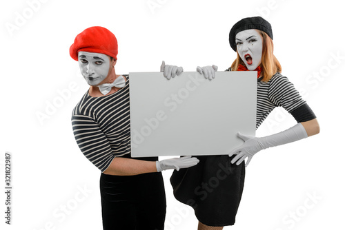 Two mimes holding big white board. Studio shot of man and woman photo