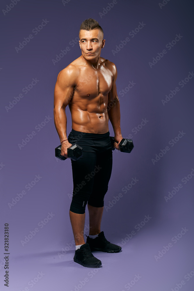 Fototapeta premium serious athlete with dumbbells in hands looking aside, full length photo, isolated blue background, studio shot, healthy life , man leads healthy lifestyle