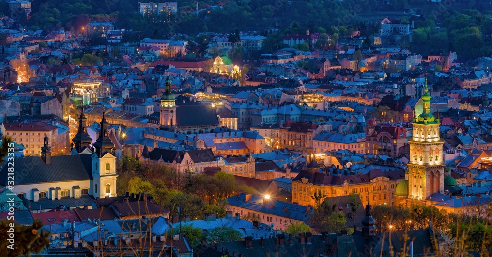Aerial night view of historical old city district with churches, cathedrals and houses roofs in Lviv, Ukraine.