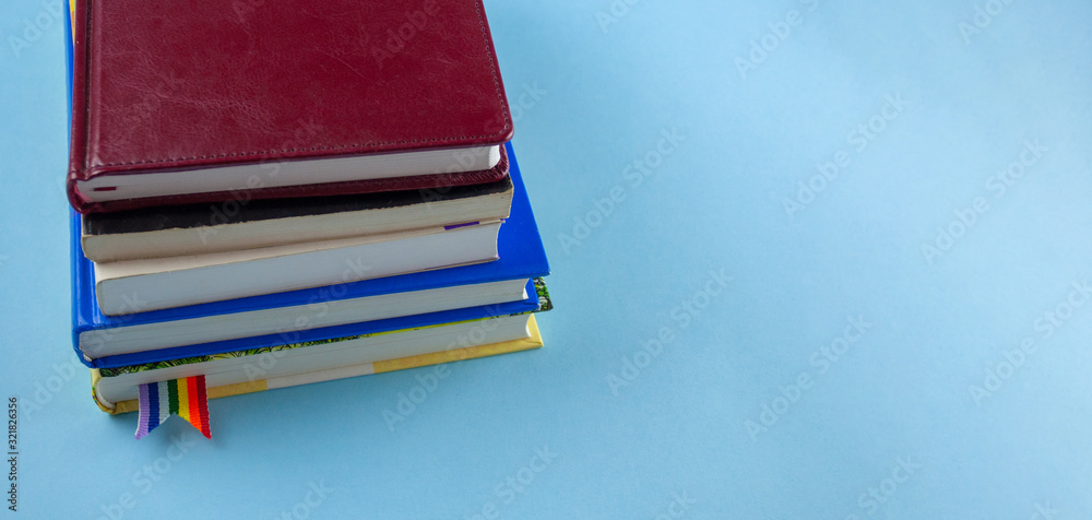 Book Stack With Ribbon Mark a stack of books with rainbow ribbon bookmarks is on the table. Concept ...