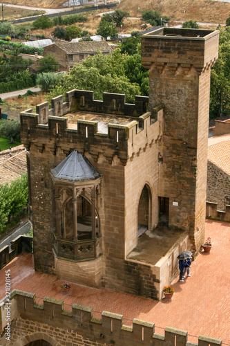 Towers of the Royal Palace of Olite and bell tower of the Church of San Pedro with the city of Olite in the background on a cloudy day