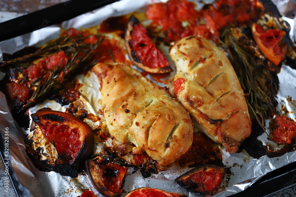 Baked chicken fillet with grapefruit and rosemary on a baking sheet. Keto, Paleo, Pegan, diet. Baked chicken fillet with grapefruit and rosemary on a baking sheet. Keto, Paleo, Pegan, diet.