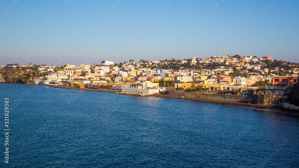 Procida (Italy) - A view of Ciraccio beach in wintertime and its typical little village with colored houses