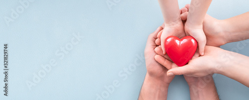 The adult and the child holding red heart.