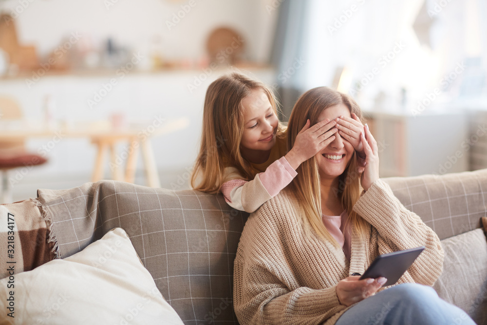 Warm toned portrait of cute girl playing peek a boo with happy young mother while surprising her on Mothers day, copy space Warm toned portrait of cute girl playing peek a boo with happy young mother while surprising her on Mothers day, copy space